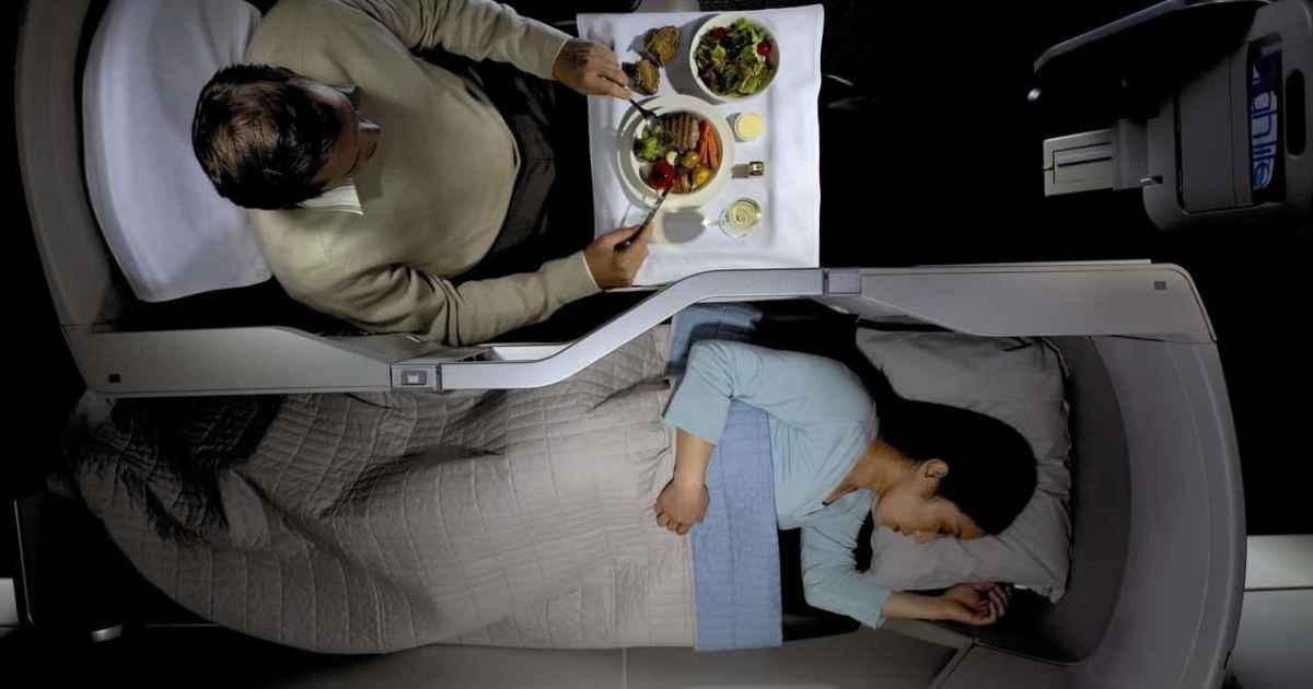 Passenger sleeping and eating in British airways business class seats
